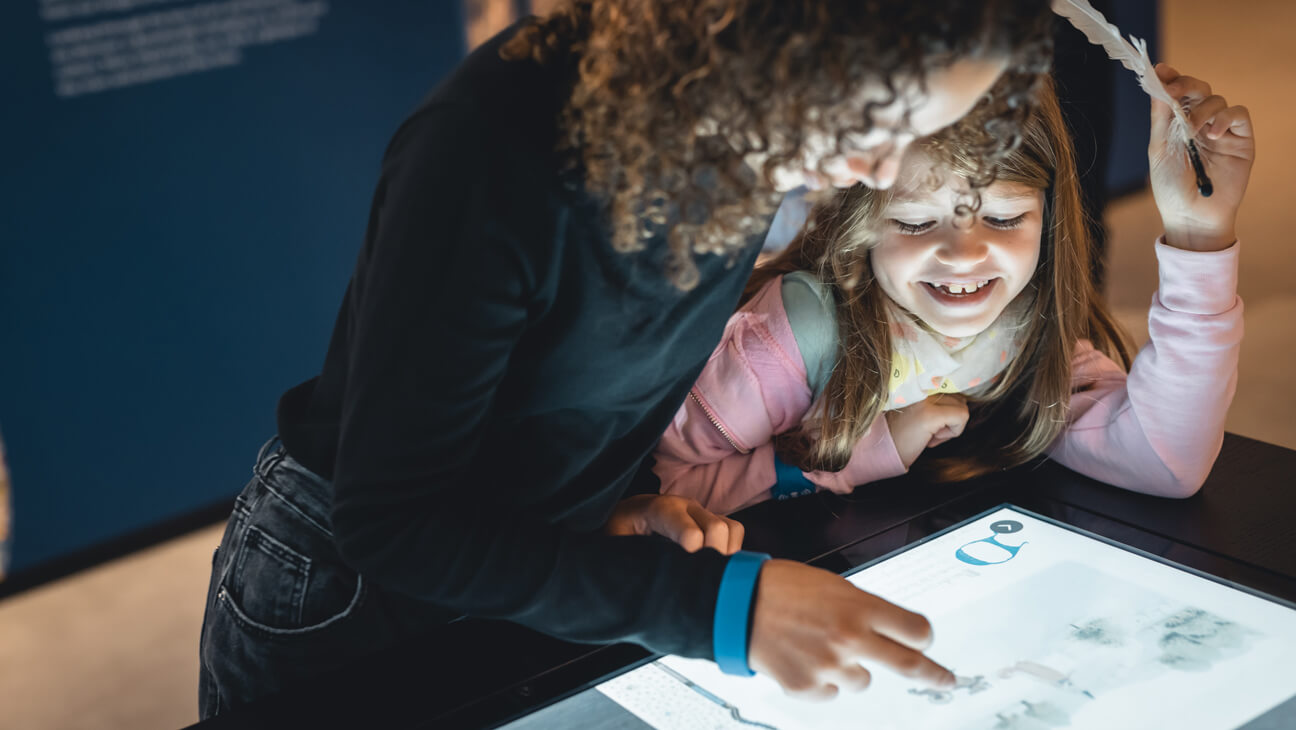 Jongeren werken op interactief-scherm in KBR museum