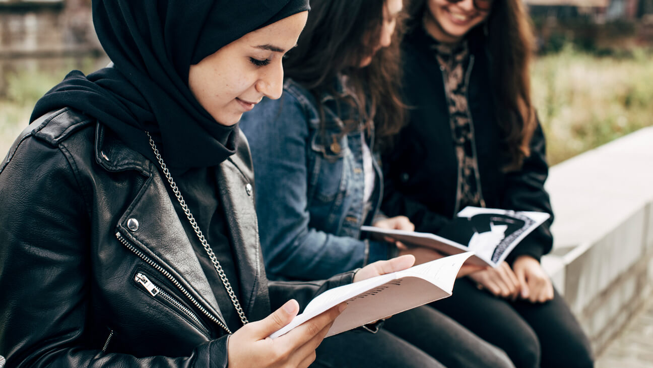 OKNA-leerling leest in handboek Overhaald