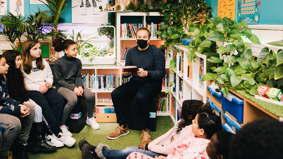 Leraar leest voor in boekenhoek