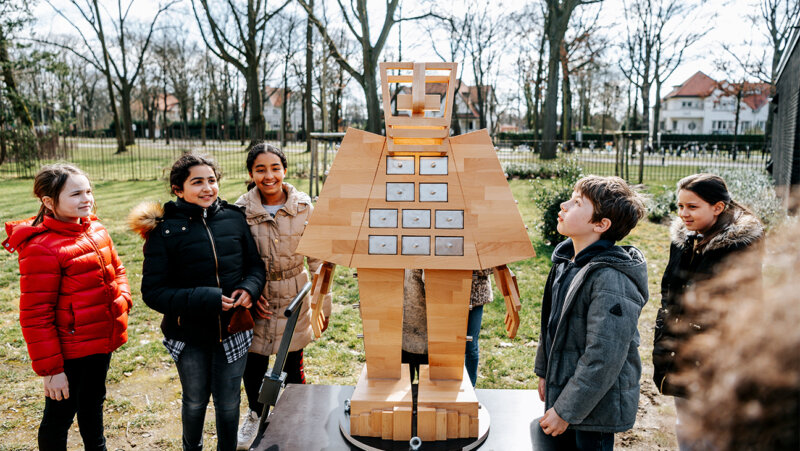 leerlingen fluisteren in het oor van 'Cosmogolem'