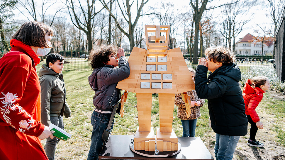 leerlingen fluisteren in het oor van 'Cosmogolem'