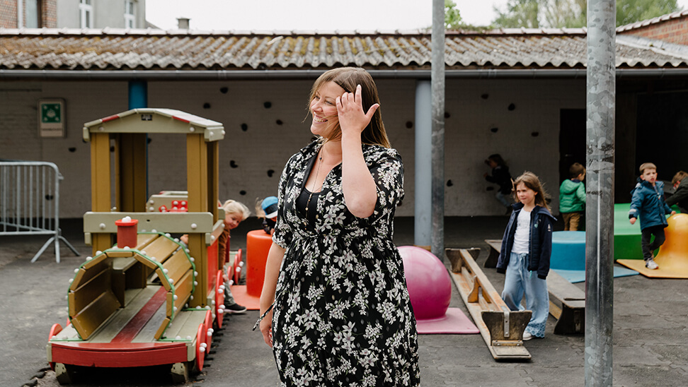 Leraar Corine met haar kleuters op de speelplaats