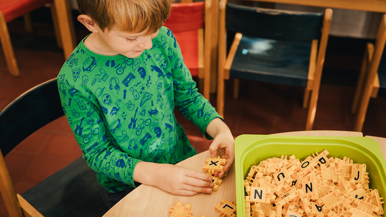 Kind aan het spelen met letterblokken