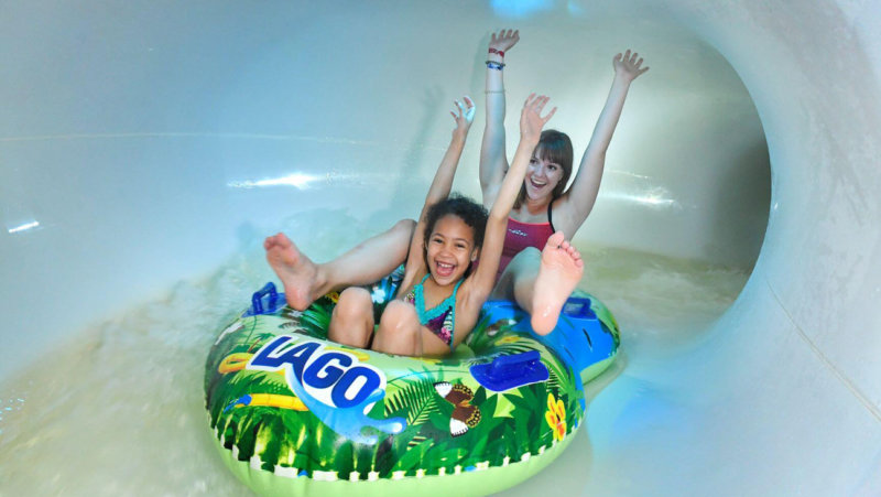 kinderen glijden uit wildwaterglijbaan