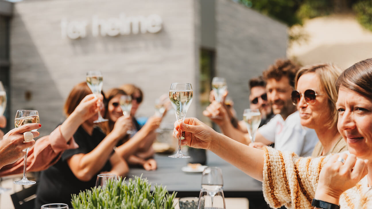 Mensen klinken met een glas champagne op een terras