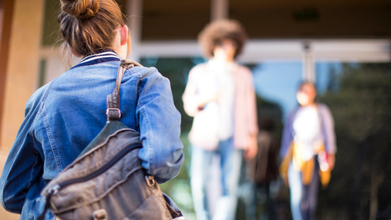 Meisje mer rugzak voor schoolgebouw - Start schooljaar