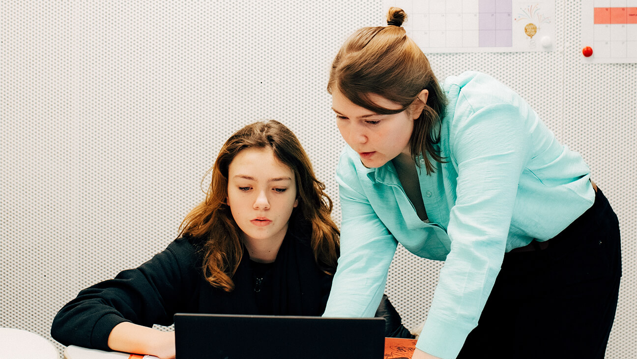 Femke Van Goethem bij een leerling in de klas