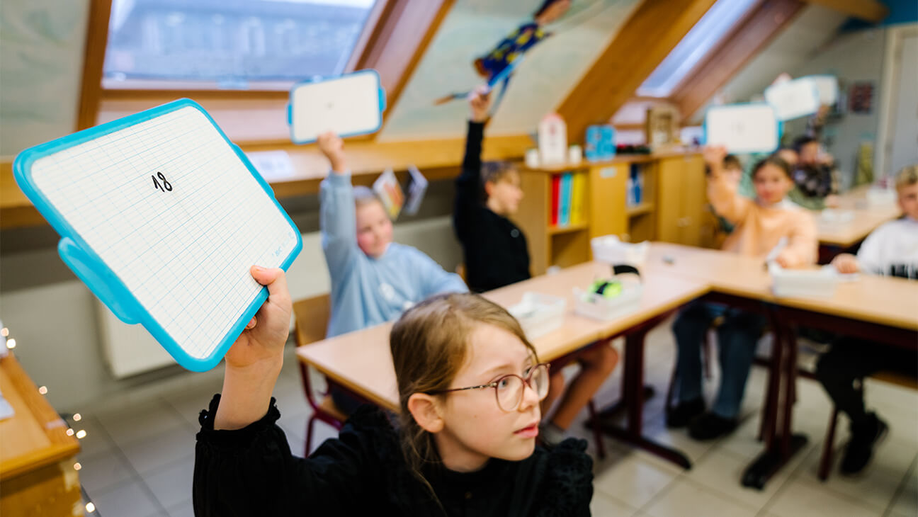 Leerling houd een bordje omhoog in de klas