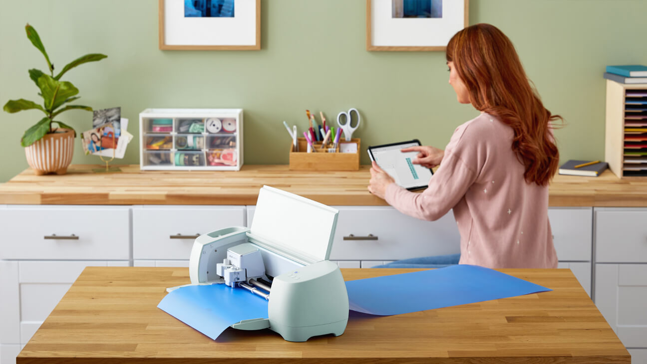 Vrouw werkt op een tablet bij een snijplotter van DS Printstudio