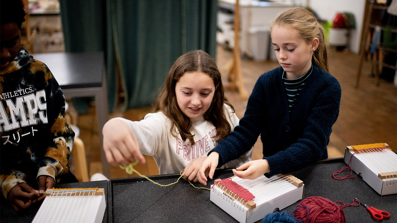 Kinderen werken aan een weefdoos