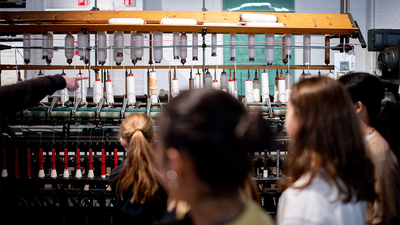 Klas bij een weefgetouw in het industriemuseum in Gent