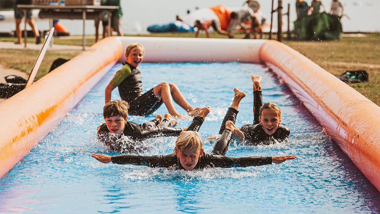 Kinderen op een waterglijbaan - Pelican