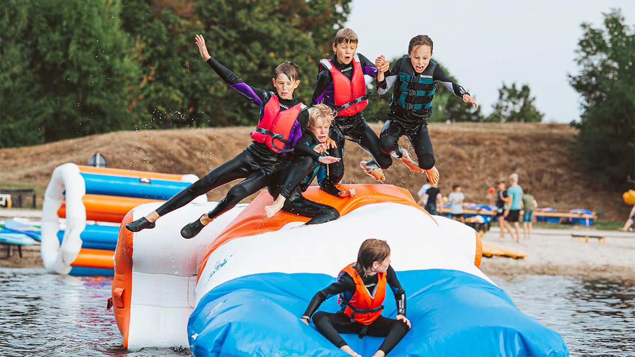 Kinderen op springkasteel in het water