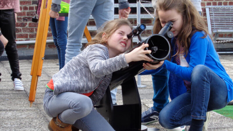 Meisjes kijken door sterrekijker