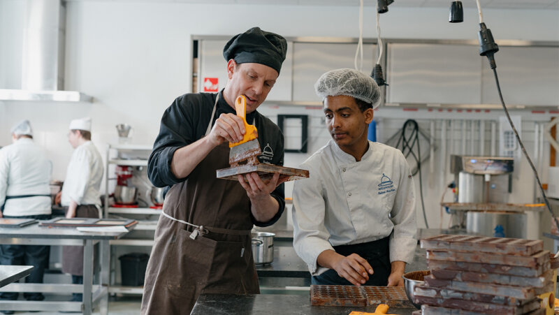 Leraar en leerling maken chocolade