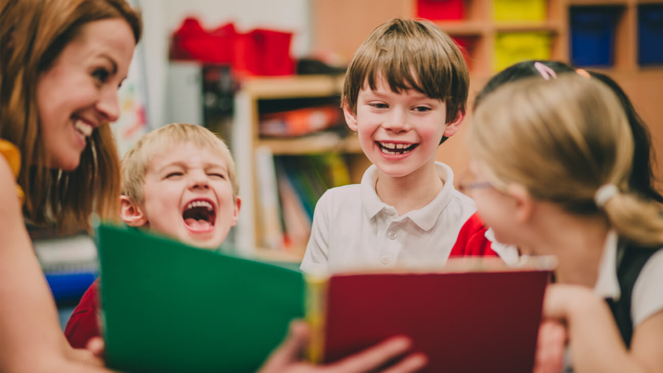 Lagere schoolkinderen lezen samen een boek in de klas.