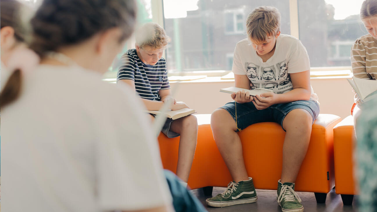 Leerlingen lezen een boek in de klas