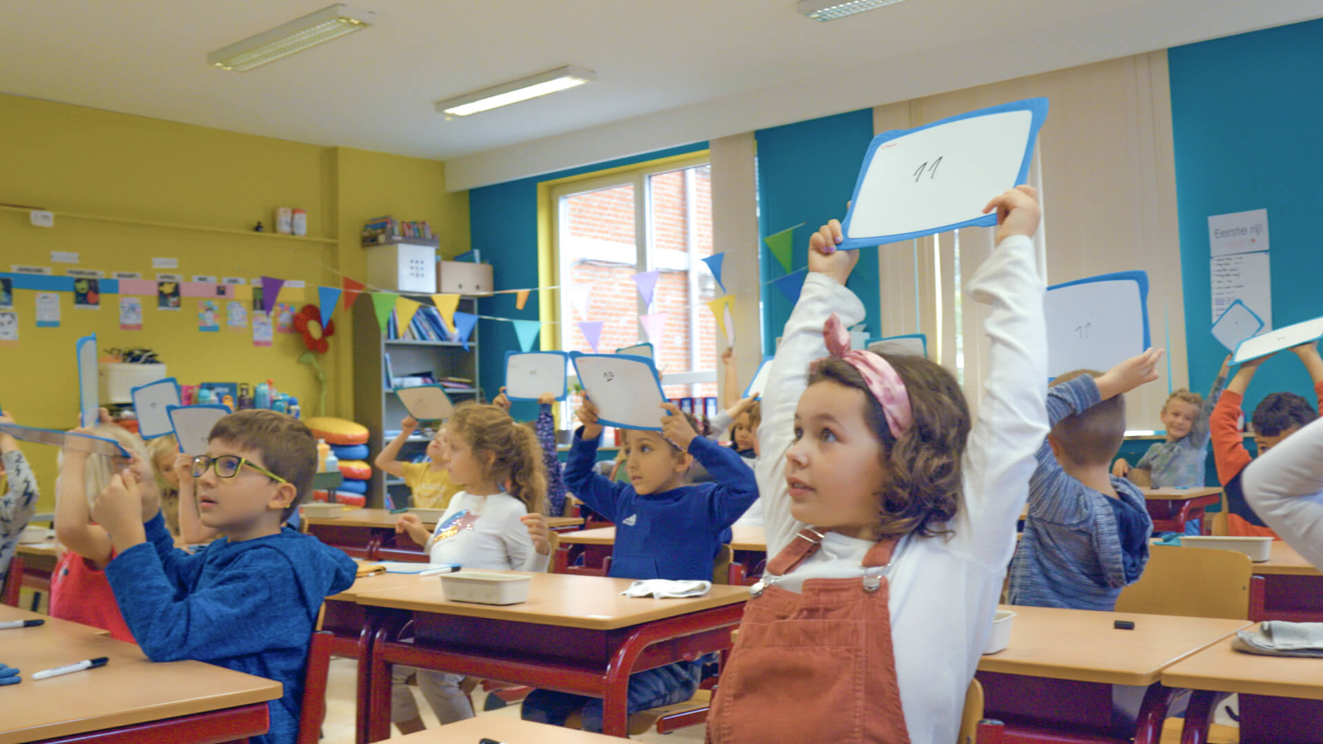 leerlingen in de klas steken een bordje met een cijfer op