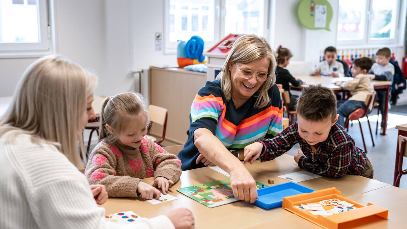 Directeur Lieve Venken speelt een bordspel samen met leerlingen