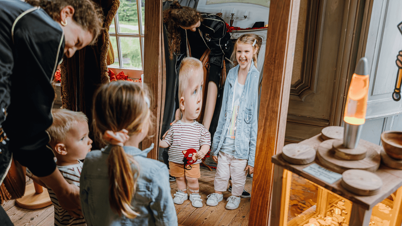 Kinderen kijken in een lachspiegel tijdens de Ridder Muis doe‑expo