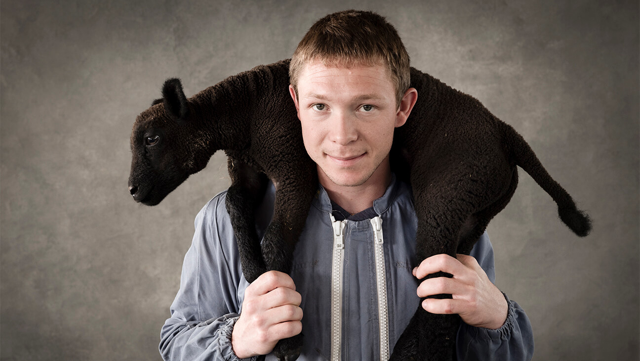 Foto van een man met schaap in zijn nek
