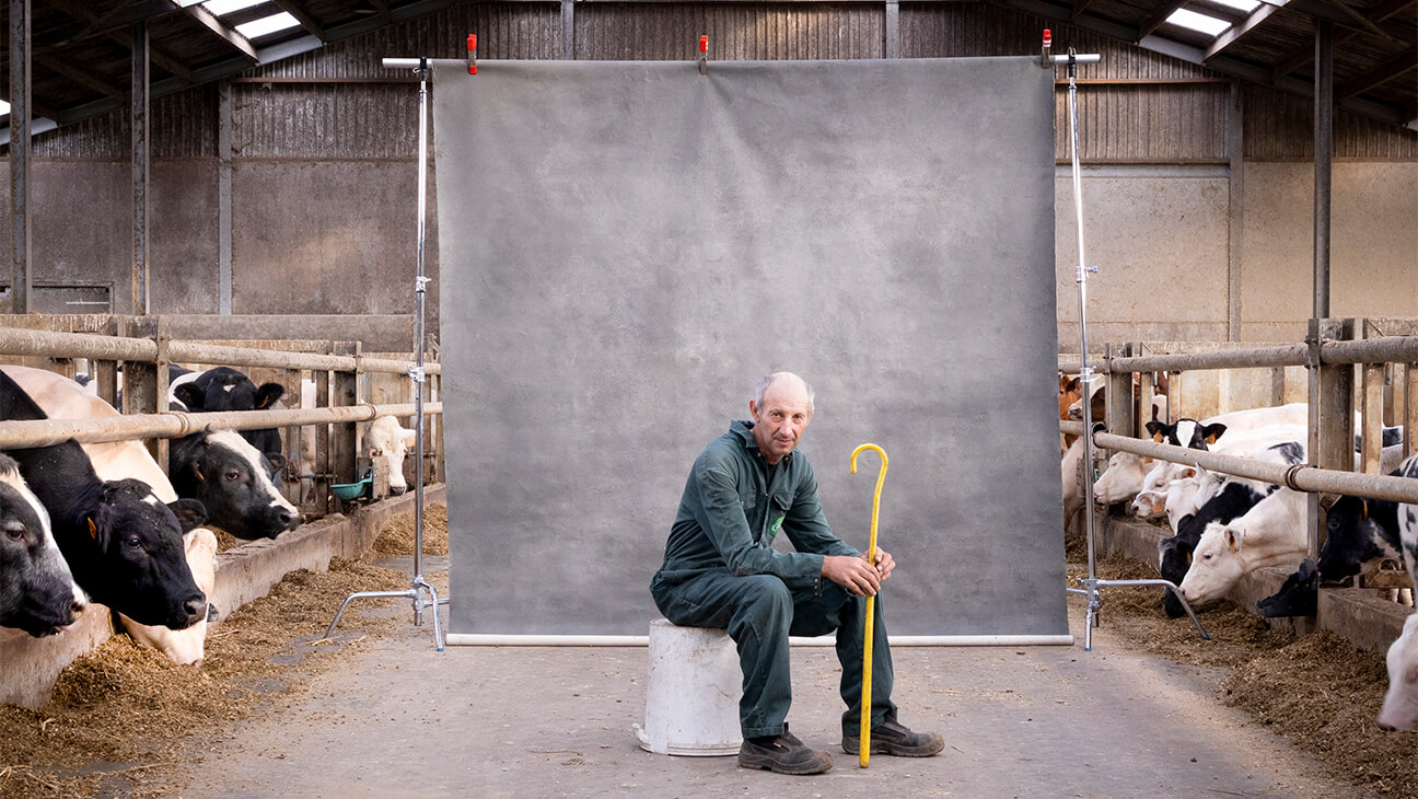 Foto van een boer in een koeienstal