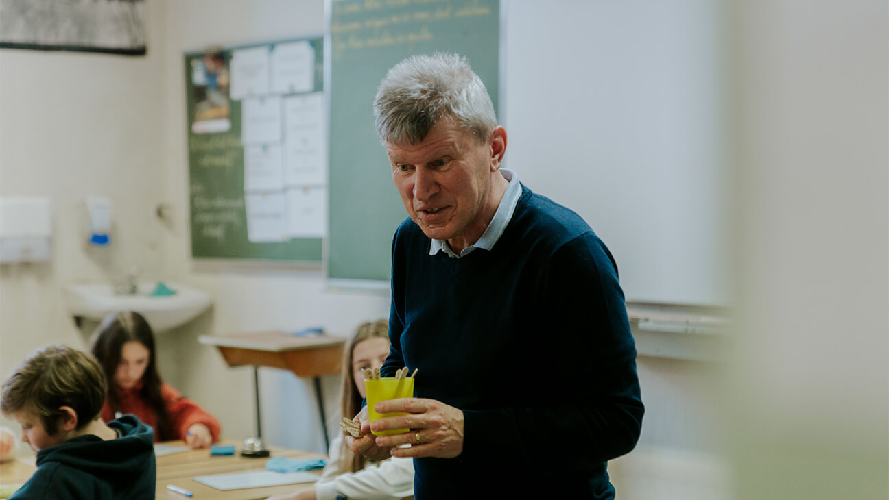 Leraar Peter Hemelsoet met in zijn hand friscostokjes met namen van de leerlingen