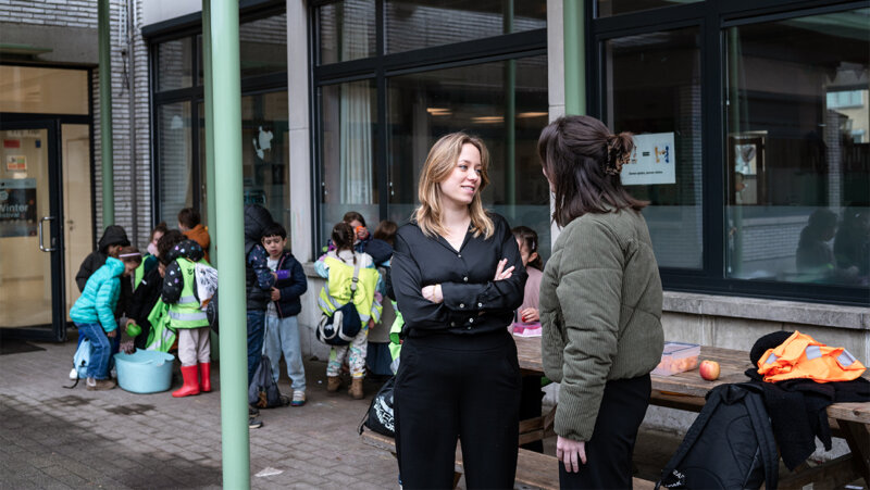 Directeur Kelly Thyssen in overleg met een leraar op de speelplaats