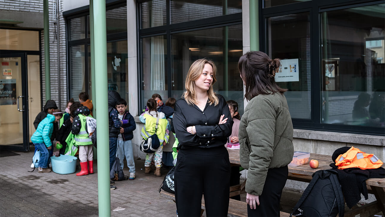 Directeur Kelly Thyssen in overleg met een leraar op de speelplaats