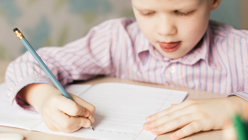 Aanvankelijk lezen en schrijven: kind oefent op schrijven in de klas