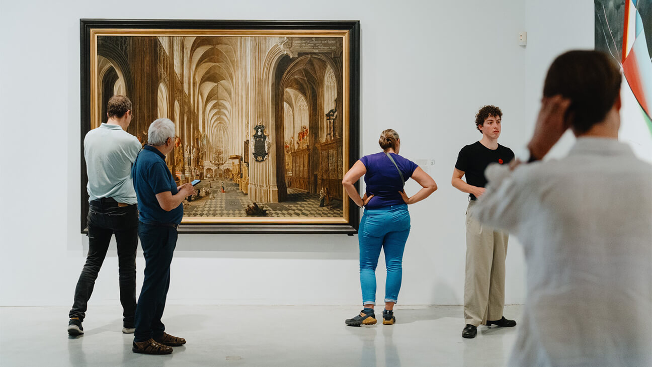 Bezoekers kijken naar kunstwerken op de expo 'Collectie van M'