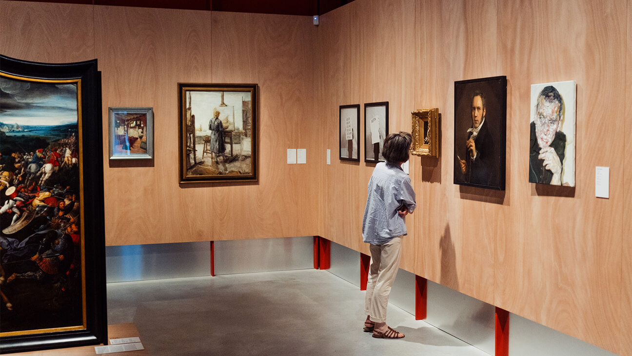 Bezoekers kijken naar kunstwerken op de expo 'Collectie van M'