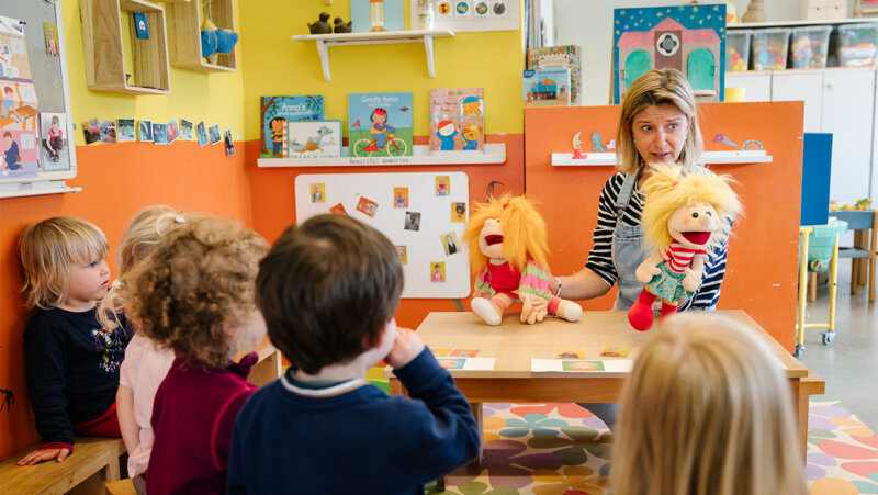 leraar Ils De Proost met haar handpoppen in de kleuterklas