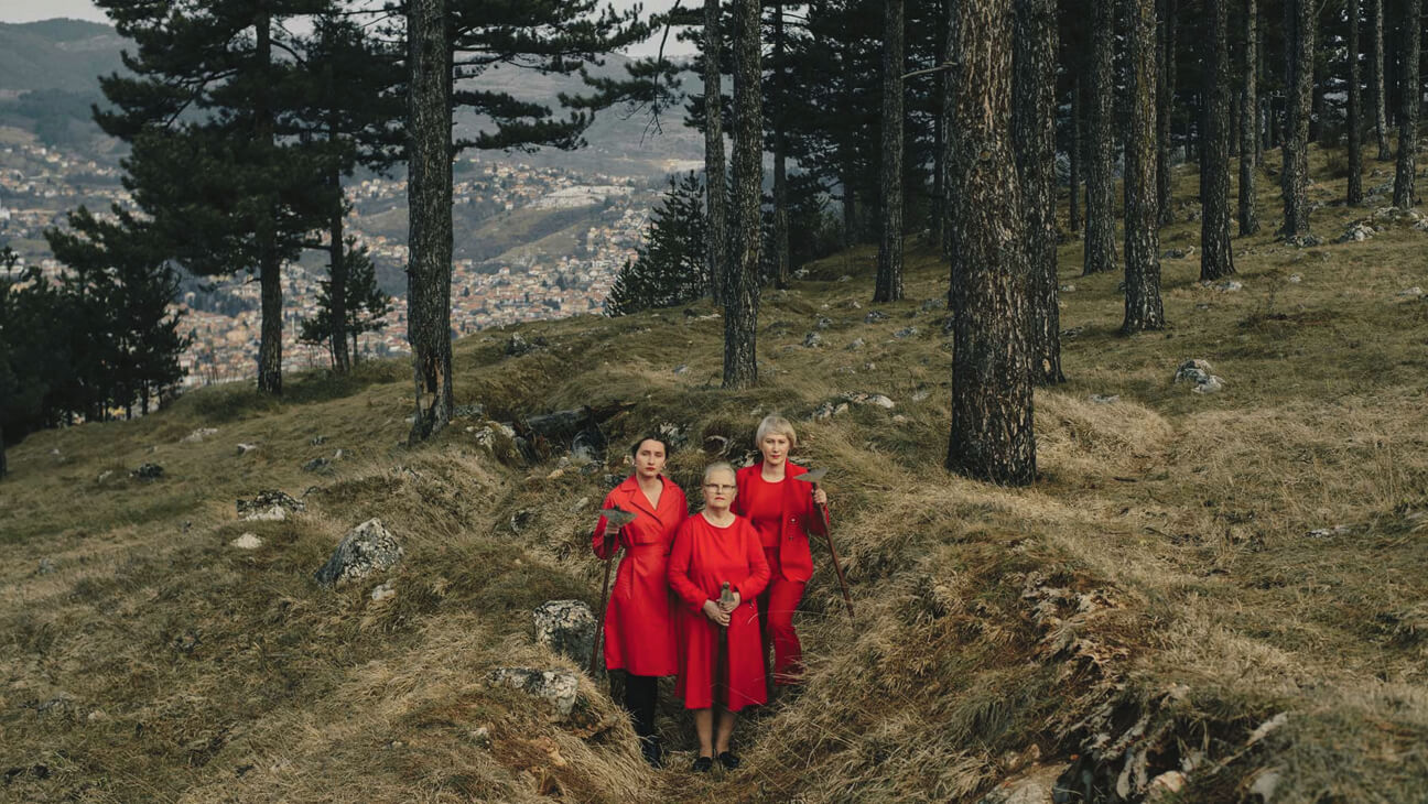 Grootmoeder, moeder en dochter bewerken de grond om bloemen te kunnen planten in de voormalige loopgraven die dienden voor de belegering van Sarajevo (1992 tot 1996)