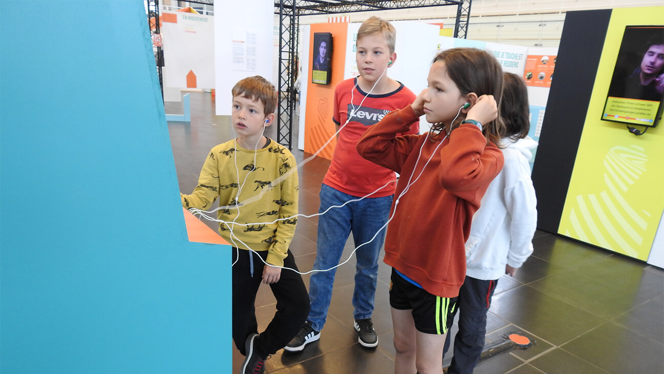 Kinderen luisteren met hoofdtelefoon in de expo 'illusie'