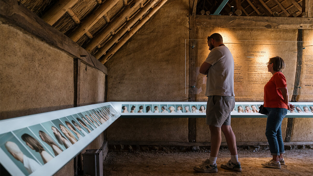 Bezoekers kijken naar foto's op de expo 'Moederziel'