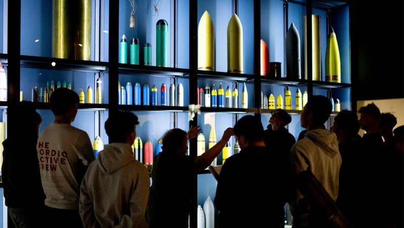 Leerlingen voor een rek met obussen op Belevingstocht in Passchendaele Museum