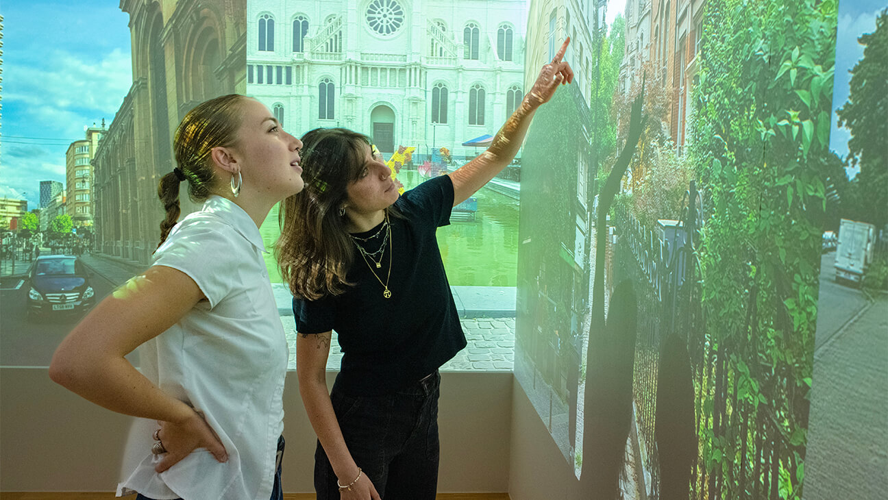 Vrouwen kijken naar foto op de Expo Raising our roots - Bruxelles à travers onze ogen