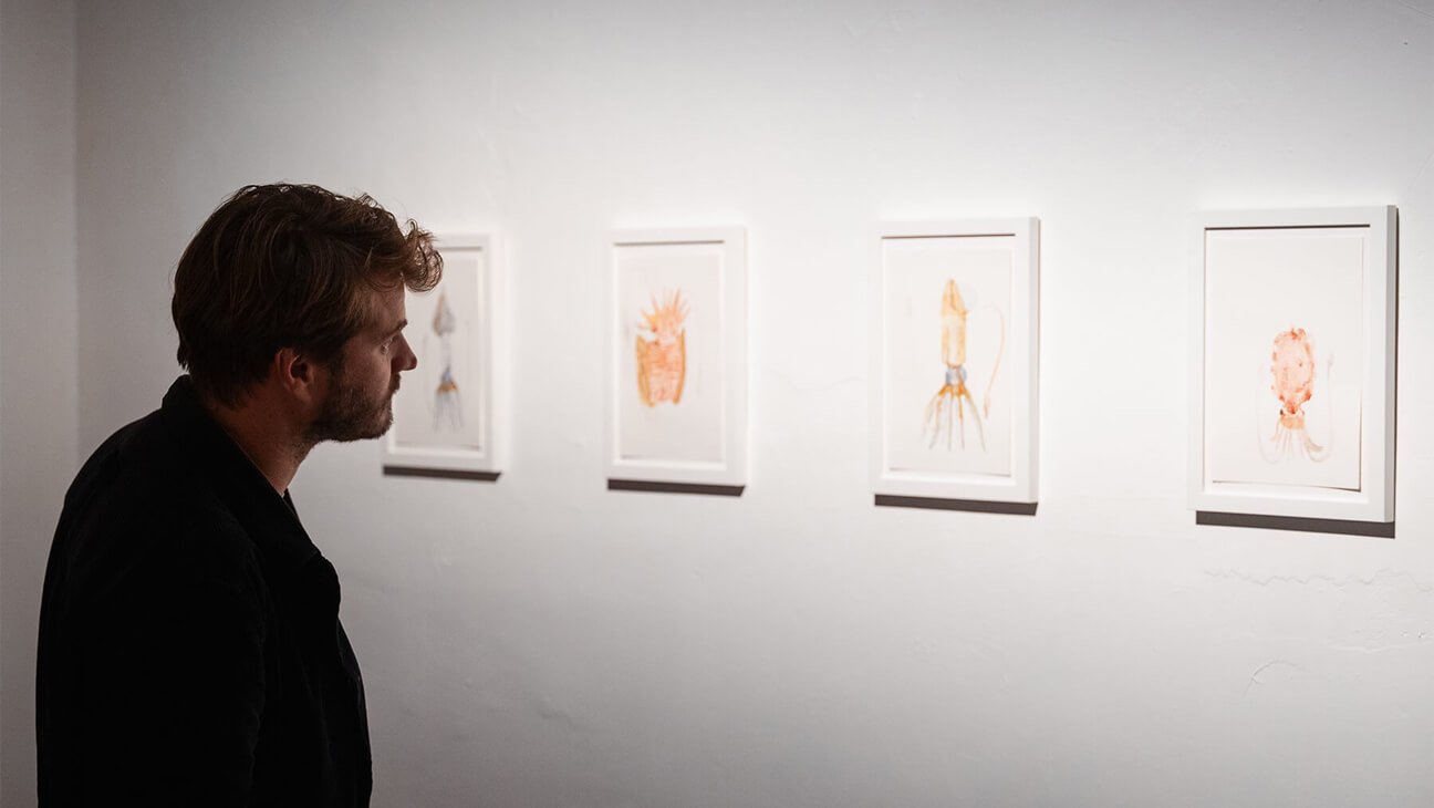 bezoeker bij kunstwerken op de expo Sea Through Skin