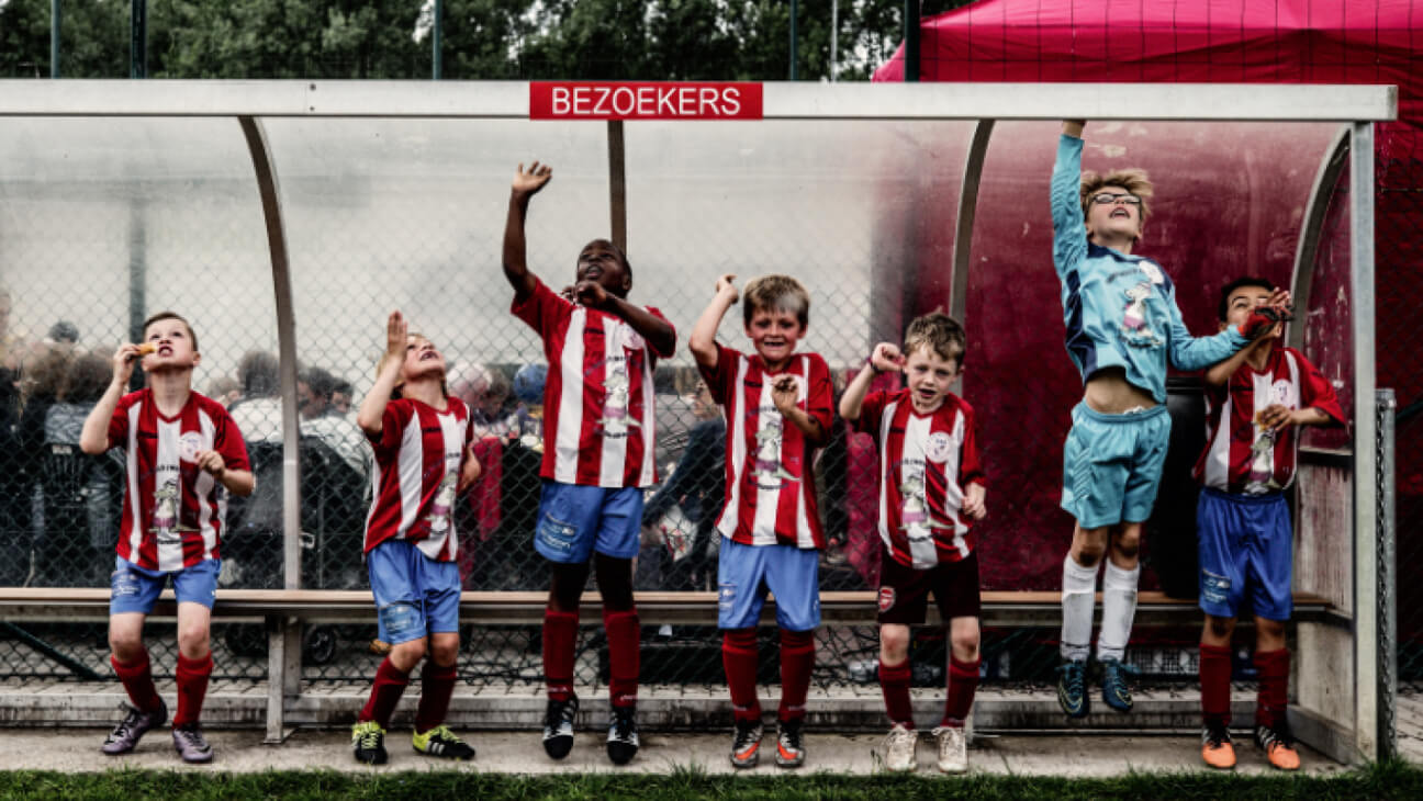 Kinderen in een dug-out op het voetbalveld