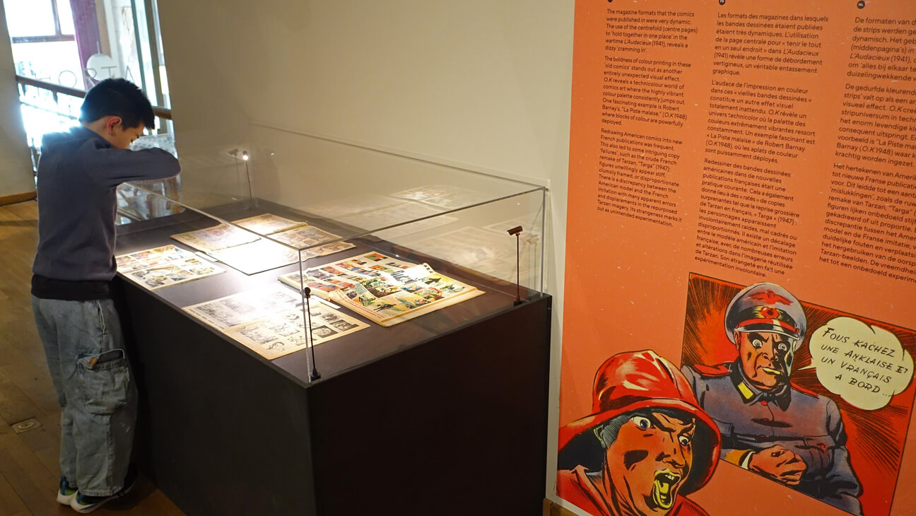 Bezoeker bekijkt vitrine van de expo Visionary Comics