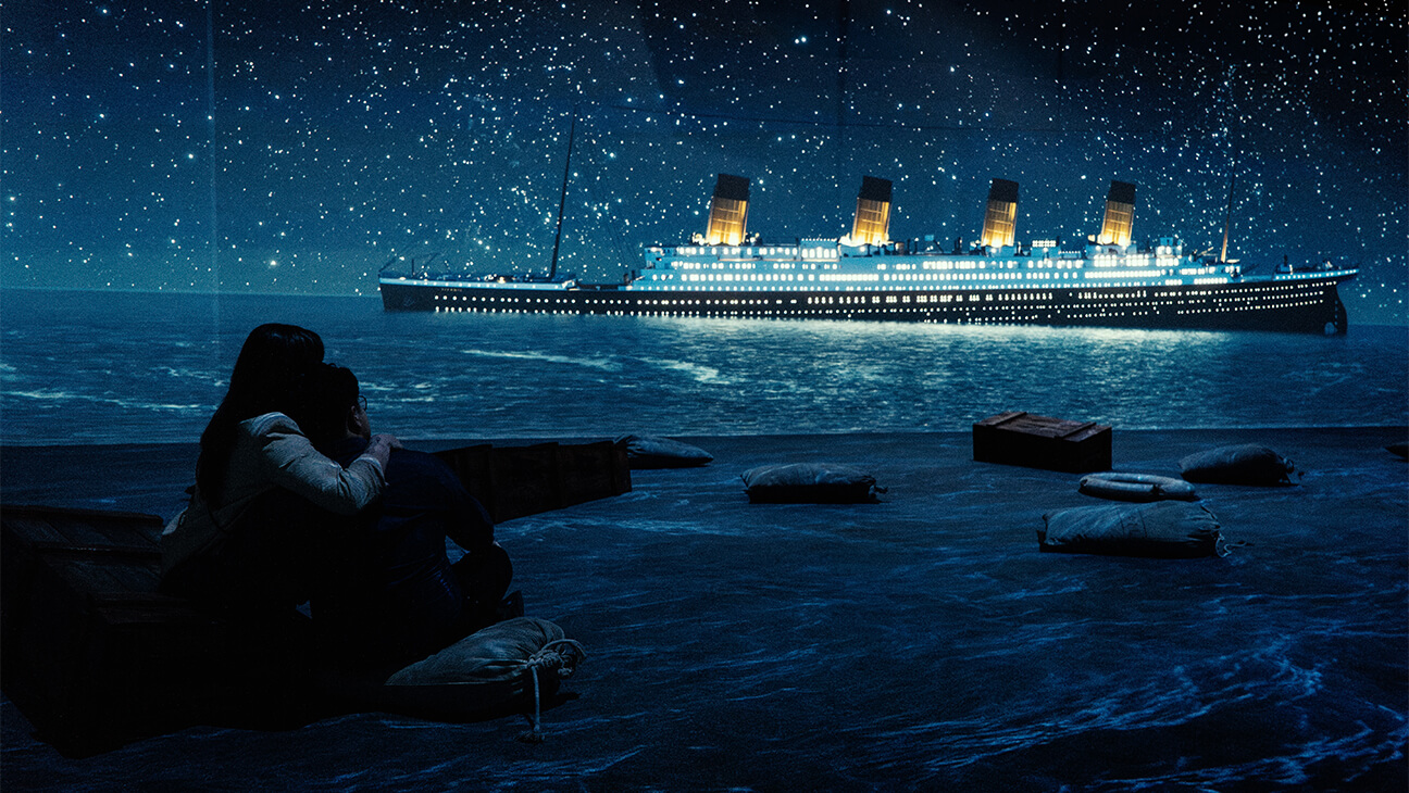 2 mensen kijken naar de titanic die zinkt