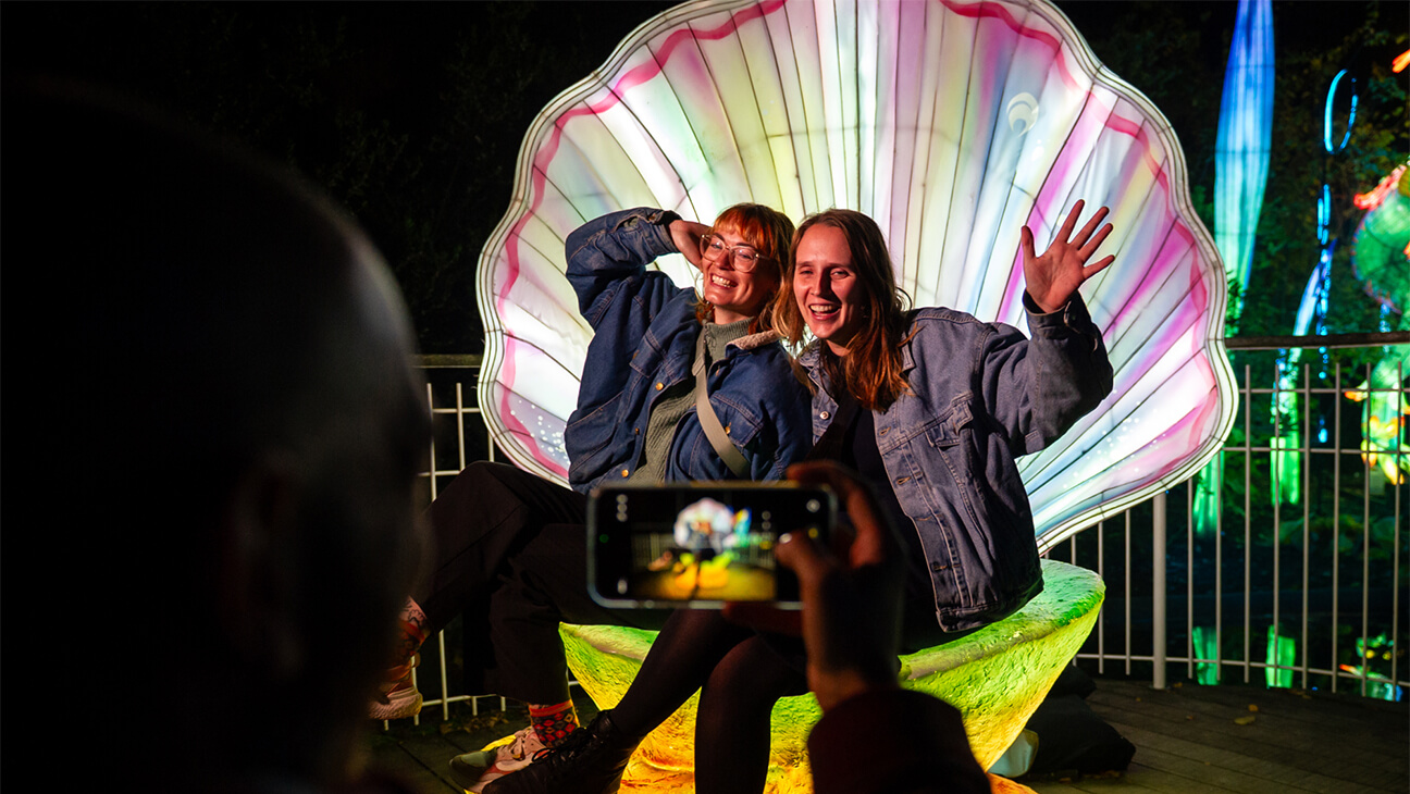 2 bezoekers in een grote, lichtgevende schelp tijdens 'Magic ocean'