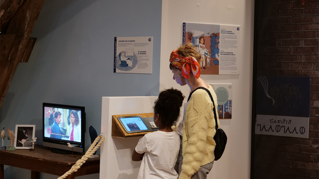 Moederen en kind bij een scherm tijdens de expo 'Beldavia'