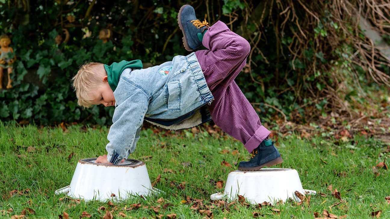 Jongen speelt in de tuin met schoenen van Schoenwinkel Hippeschoentjes