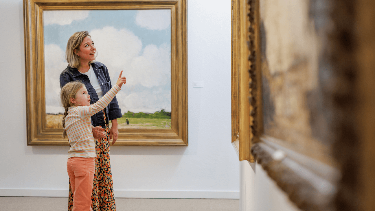 Kind met vrouw kijken naar schilderijen