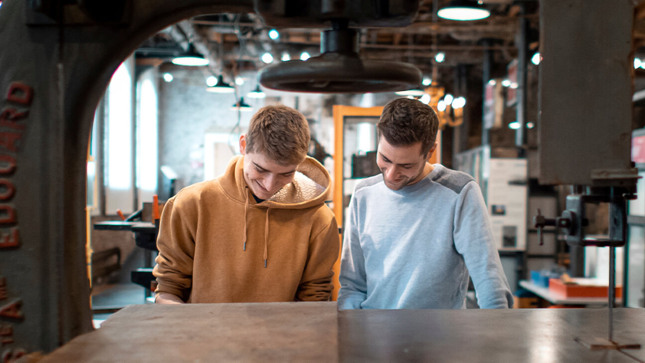 Bezoekers aan de expo 'Made in Brussels' bij een oude machine