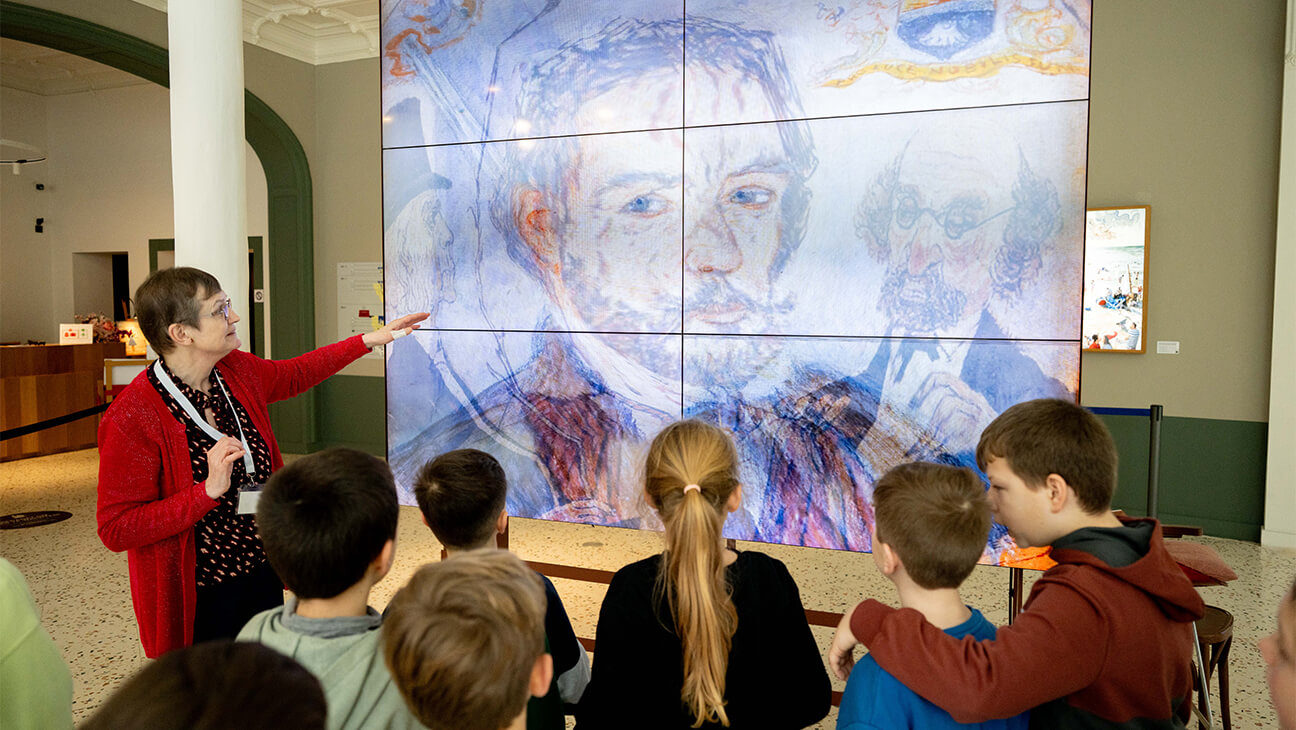 Leerlingen kijken naar een digitaal portret van James Ensor in het James Ensorhuis